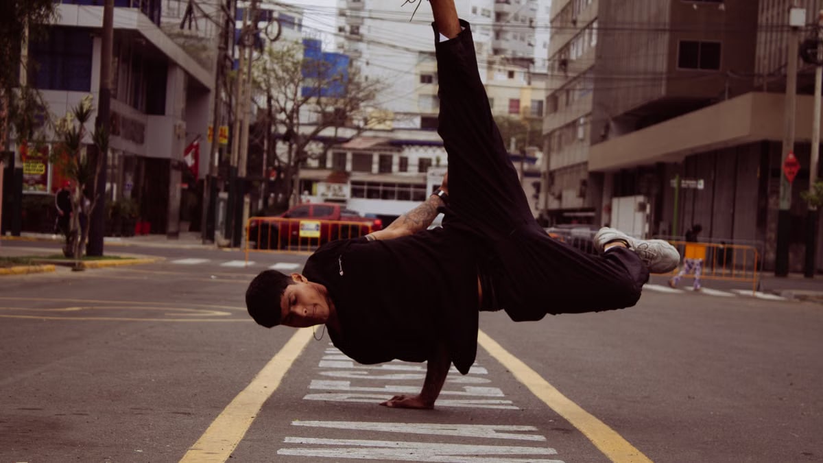 Urban street dancer performs impressive breakdancing move in downtown Lima, Peru.